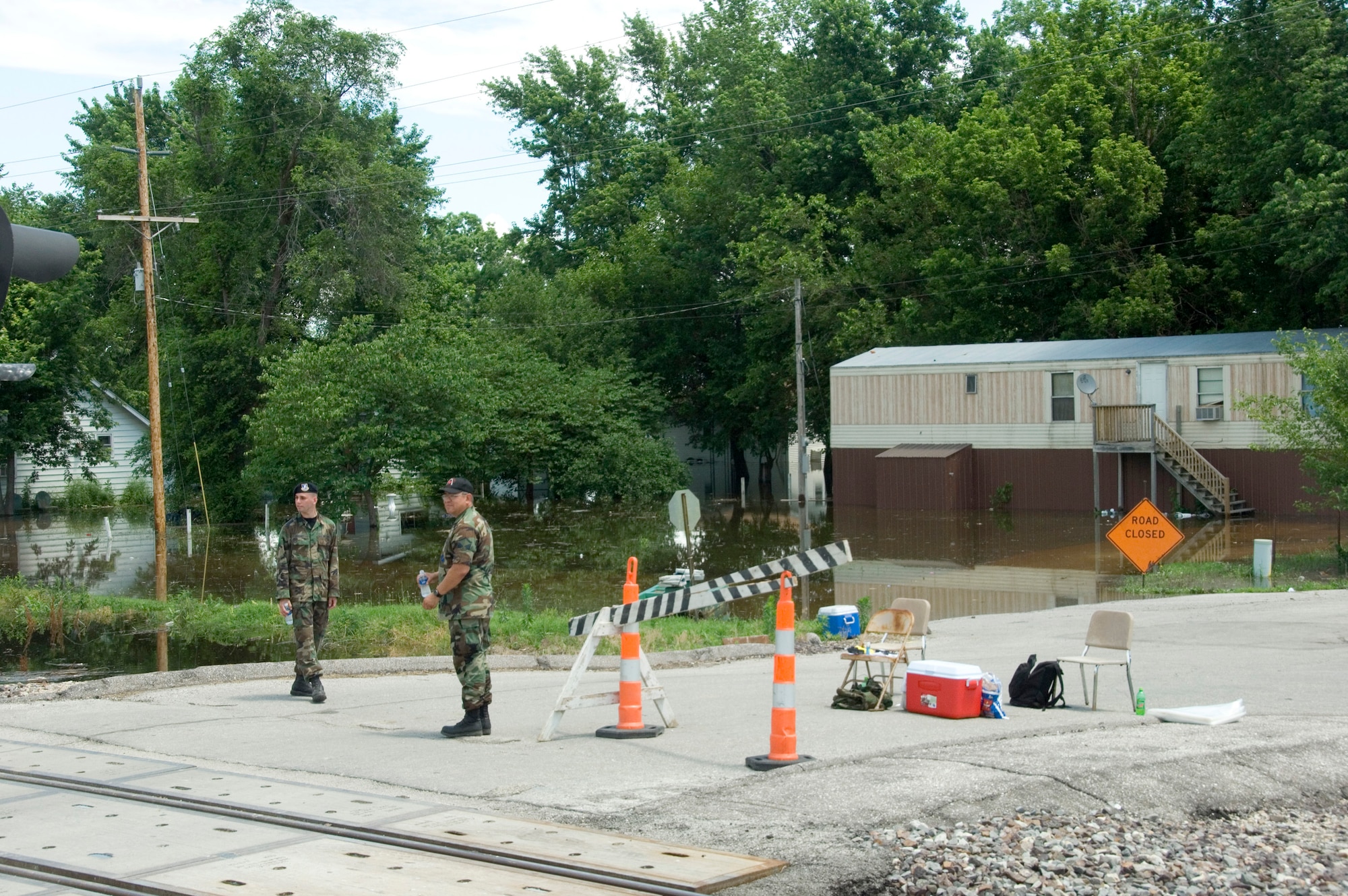 Master Sgt. Chris Montoga, right, and Airman First Class Jon Taggart man a checkpoint in Foley, Mo., June 20. Checkpoints manned by members of the Missouri Air National Guard are set up along a 30-mile stretch of the Mississippi River near Winfield, Mo. Air National guardsmen control access to flooded areas provide a deterrent to would-be looters. Sergeant Montoga and Airman Taggart are both from the 131st Fighter Wing at Lambert Field, Mo. (U.S. Air Force photo/Master Sgt Jack Braden)
