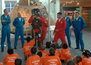 LANGLEY AIR FORCE BASE, Va. -- Graham Duff, British Royal Air Force Red Arrows pilot and squadron leader, demonstrates putting on his flight gear at the Virginia Air and Space Center in front of children from the Suffolk YMCA June 20. The Red Arrows will perform at AirPower over Hampton Roads. Langley’s annual open house is an event that helps educate the public, increase recruiting and show appreciation to the local community. (U.S. Air Force photo/Airman 1st Class Aaron Johnson)