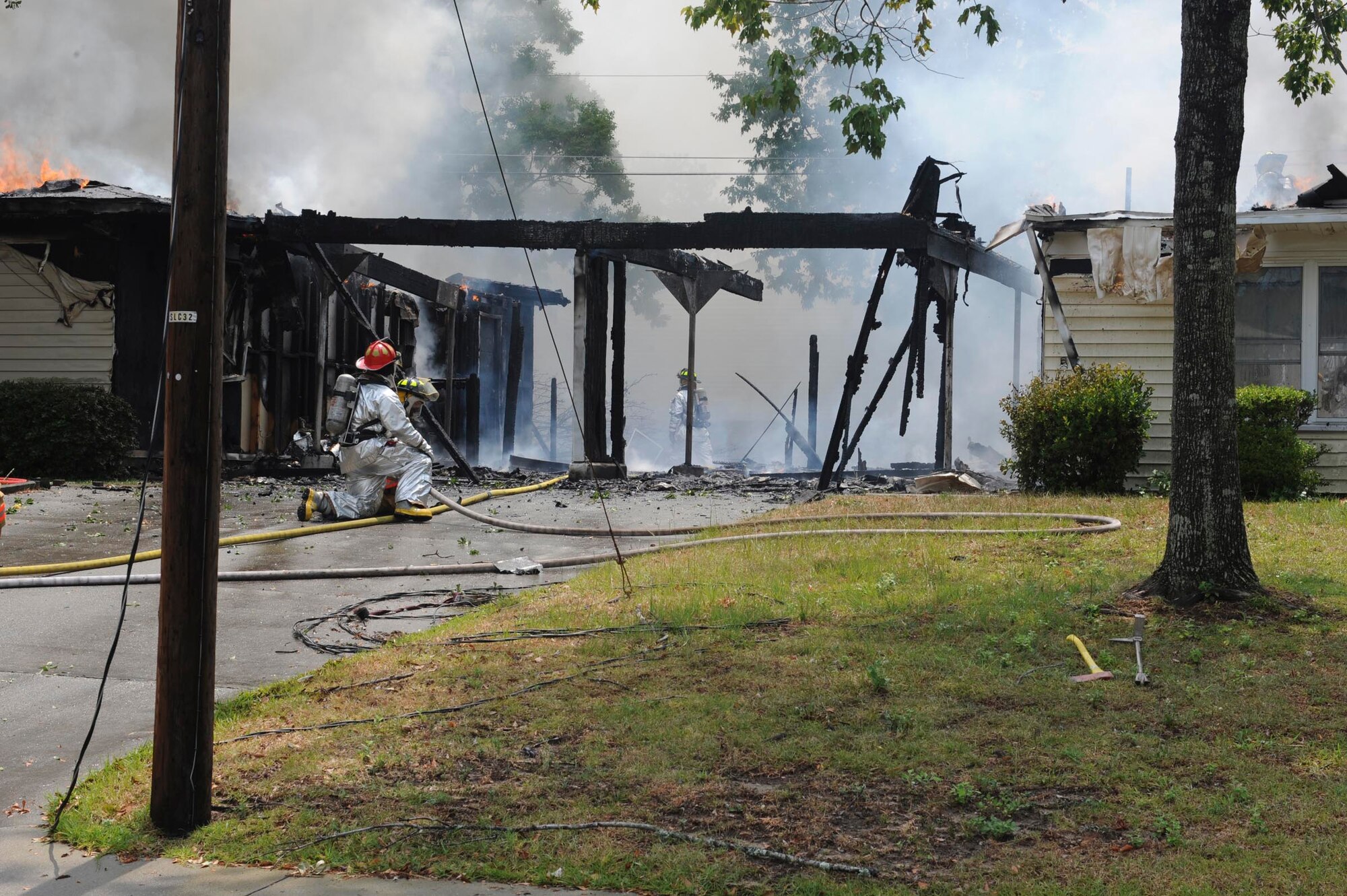 SHAW AIR FORCE BASE, S.C.-- Shaw firemen work together to extinguish a house fire on base June 20. The house was in one of the areas scheduled for demolition and was unoccupied at the time. (U.S. Air Force photo/Staff Sgt. Henry Hoegen)