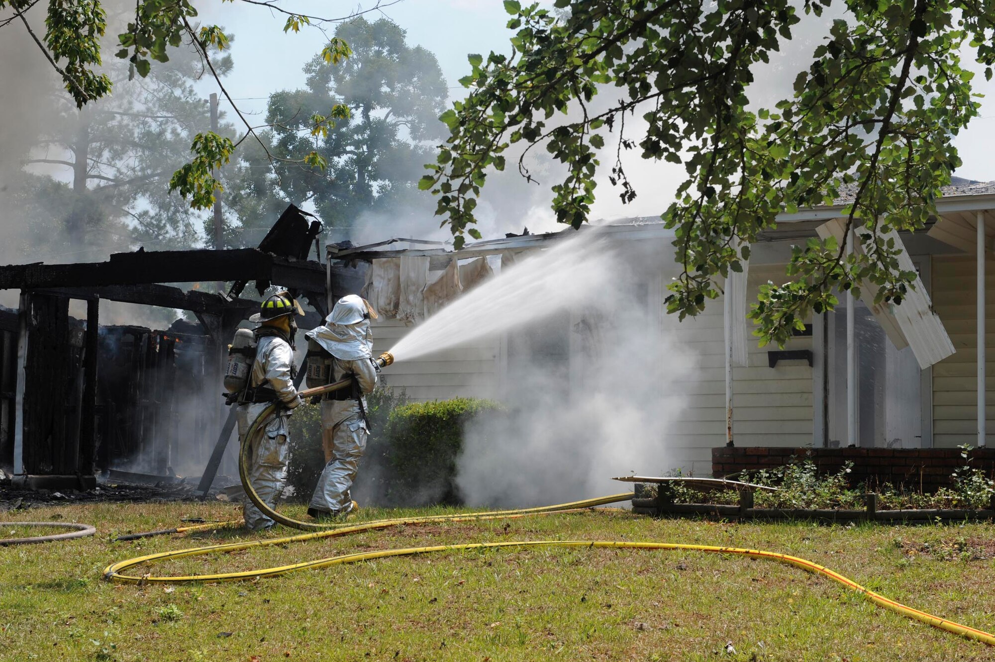 SHAW AIR FORCE BASE, S.C.-- Shaw firemen work together to extinguish a house fire on base June 20. The house was in one of the areas scheduled for demolition and was unoccupied at the time. (U.S. Air Force photo/Staff Sgt. Henry Hoegen)
