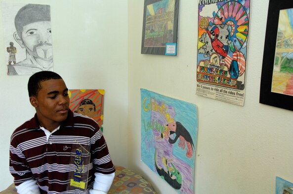 BARKSDALE AIR FORCE BASE, La. - Xavier, 13, son of Staff Sgt Donovan Pemberton reflects on his numerous works of art while holding his Art Break trophy in his family's game room. Xavier earned top middle school award at Art Break where he competed against all middle schools in Bossier and Caddo Parishes. (U.S. Air Force photo by Airman 1st Class Joanna M. Kresge)