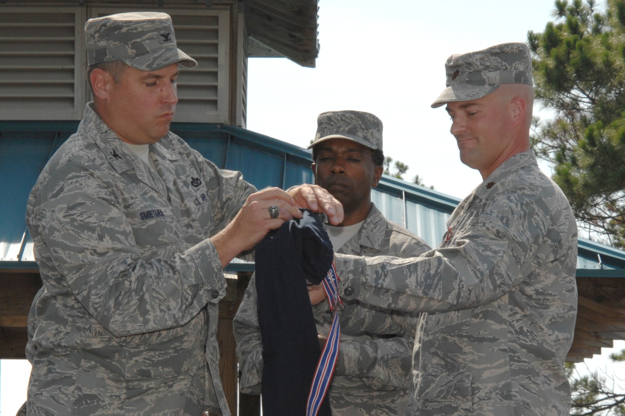 Col. Mike Smietana, 1st Special Operations Mission Support Group commander, and Maj. Paul Swenson, former 1st Special Operations Services Squadron commander, retire the 1st SOSVS guidon during a ceremony June 20. The ceremony officially marked the merger of the 1st SOSVS and the 1st Special Operations Mission Support Squadron, and the creation of the 1st Special Operations Force Support Squadron. Maj. Damon Menendez, former 1st SOMSS commander, will command the new squadron. (U.S. Air Force photo/Senior Airman Stephanie Jacobs)