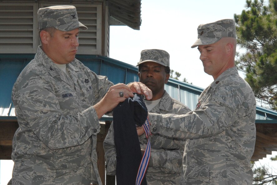 Col. Mike Smietana, 1st Special Operations Mission Support Group commander, and Maj. Paul Swenson, former 1st Special Operations Services Squadron commander, retire the 1st SOSVS guidon during a ceremony June 20. The ceremony officially marked the merger of the 1st SOSVS and the 1st Special Operations Mission Support Squadron, and the creation of the 1st Special Operations Force Support Squadron. Maj. Damon Menendez, former 1st SOMSS commander, will command the new squadron. (U.S. Air Force photo/Senior Airman Stephanie Jacobs)