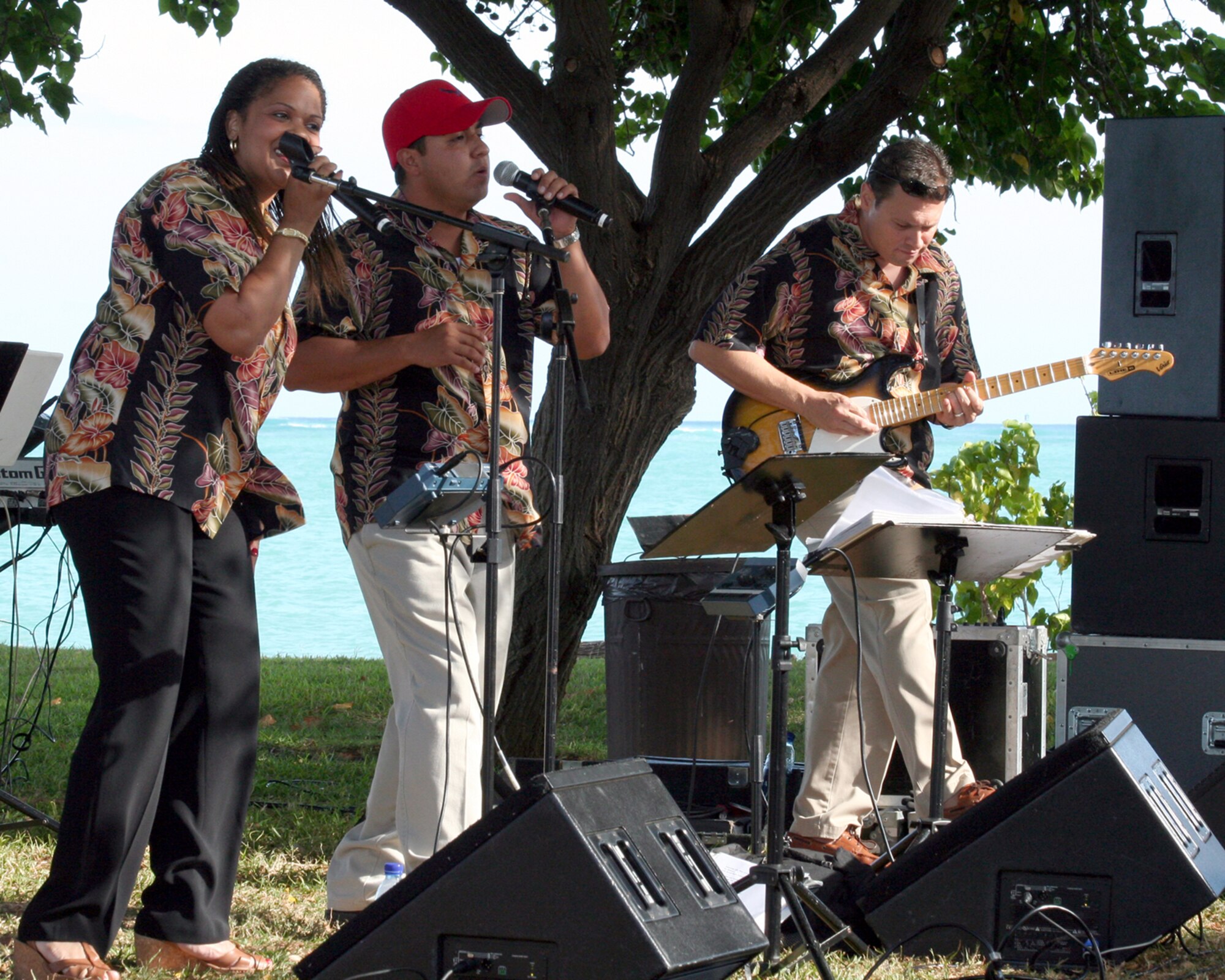 HICKAM AIR FORCE BASE, Hawaii – U.S. Air Force Staff Sergeant Tamiko Boone, vocalist, Staff Sergeant Rickard Vasquez Jr., vocalist, and Staff Sergeant Gregory S. Lacy, guitarist,  members of the Air Force Band of the Pacific, ‘Hana Hou’, perform here May 18 during a concert hosted by Col. J.J. Torres, 15th Airlift Wing commander.  Hana Hou’s performances delight military and civilian audiences throughout Hawaii and the Pacific.  (US Air Force photo/ Master Sgt. Cherie McNeill)  