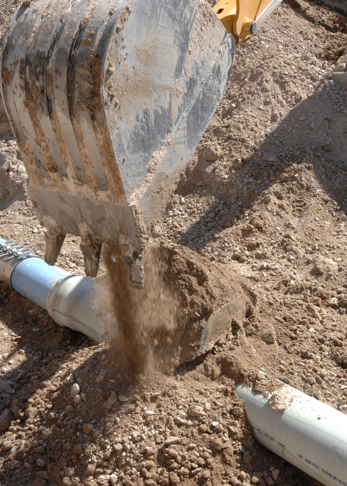 A Backhoe covers up a pipe outside of Hangar 877, June 19 on Holloman Air Force Base, N.M. The pipe had to be dug up and repaired due to a ruptured fire line.(U.S. Air Force photo/Airman 1st Class Rachel A. Kocin)