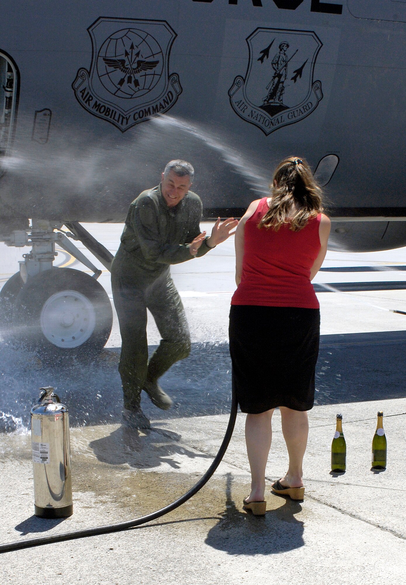 FAIRCHILD AIR FORCE BASE, Wash. – Col. Roger Watkins, 92nd Air Refueling Wing vice commander, blocks his face as his wife, Leslie, drenches him with water after his fini flight here June 18. Colonel Watkins was greeted by family and friends as he exited a KC-135, his final flight as the 92nd ARW vice commander. (U.S. Air Force photo / Airman 1st Class Melissa Barnett)