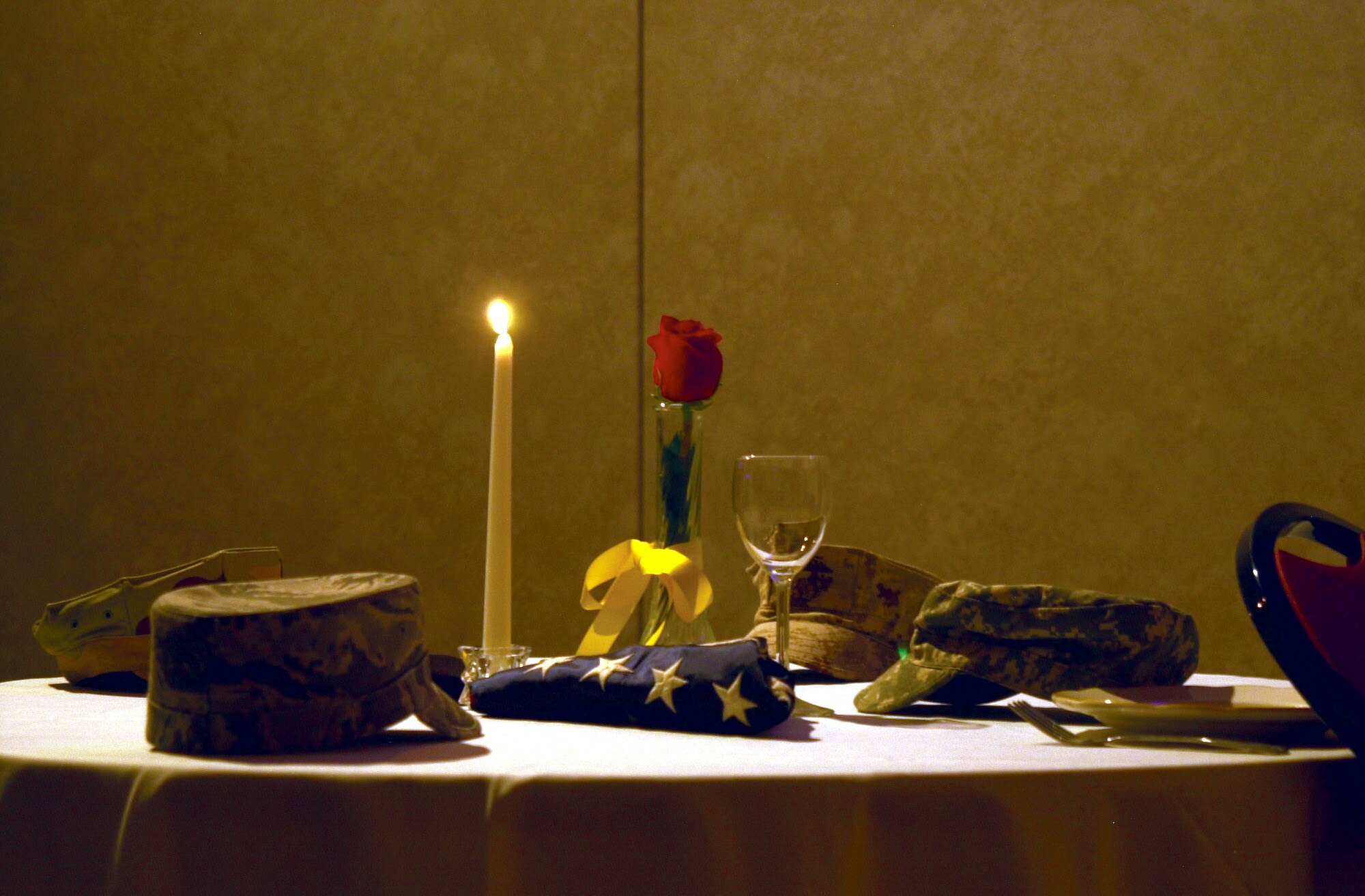 Uniform caps from the Air Force, Army, Navy and Marine Corps rest on a table in memory of servicemembers who made the ultimate sacrifice for this country at the 17th Training Wing Joint Enlisted Dining-In June 12. (U.S. Air Force photo by Senior Airman Stephen Musal)