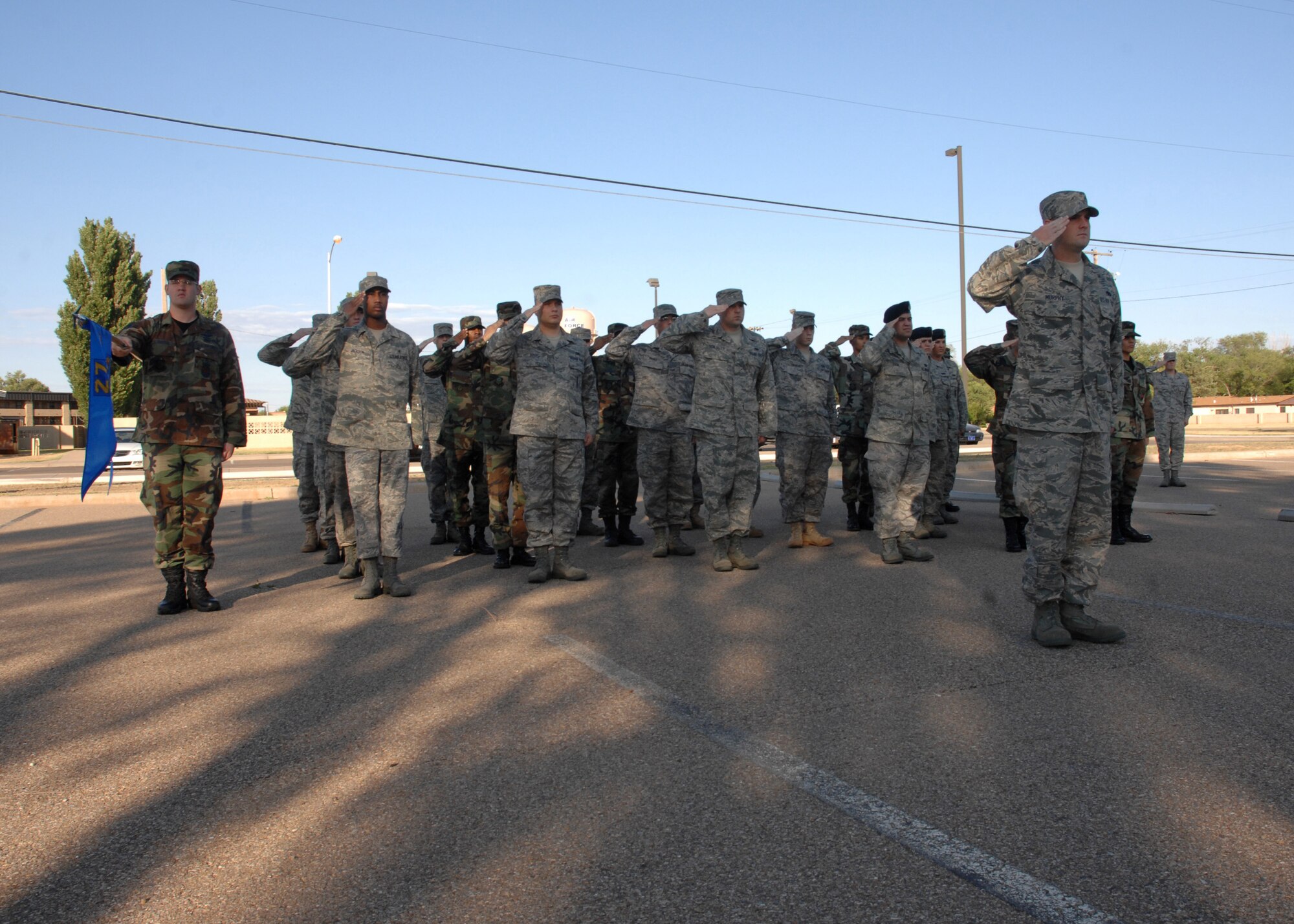 CANNON AIR FORCE BASE, N.M. -- Airmen currently in Airman Leadership School salute in front of the ALS building during reveille June 20. The current class of future NCOs graduates July 10. (U.S. Air Force photo/Airman 1st Class Evelyn Chavez)