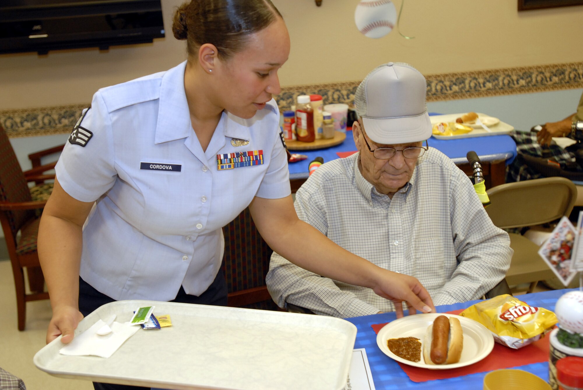 Senior Airman Christina Cordova, a member of the 17th Communications Squadron, brings lunch to a resident of the Big Spring Veterans Hospital during a visit June 16.  Members of Team Goodfellow spent several hours talking to and eating with veterans. (U.S. Air Force photo by Master Sgt. Randy Mallard)