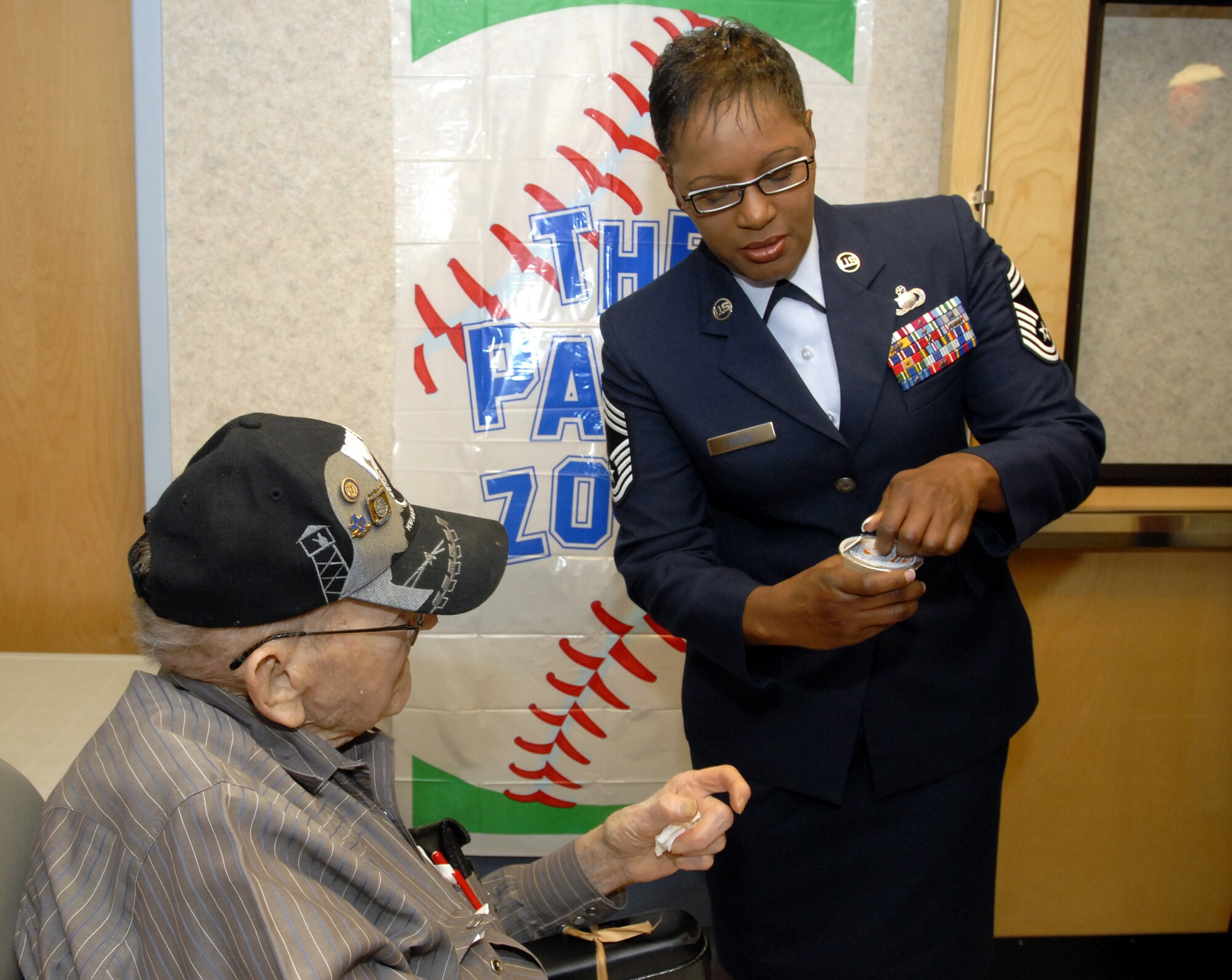 Chief Master Sgt. Wanda Floyd helps Mr. Jimmy Burt, a resident at the Big Spring Veterans Hospital, open a juice pack June 16. (U.S. Air Force photo by Master Sgt. Randy Mallard)