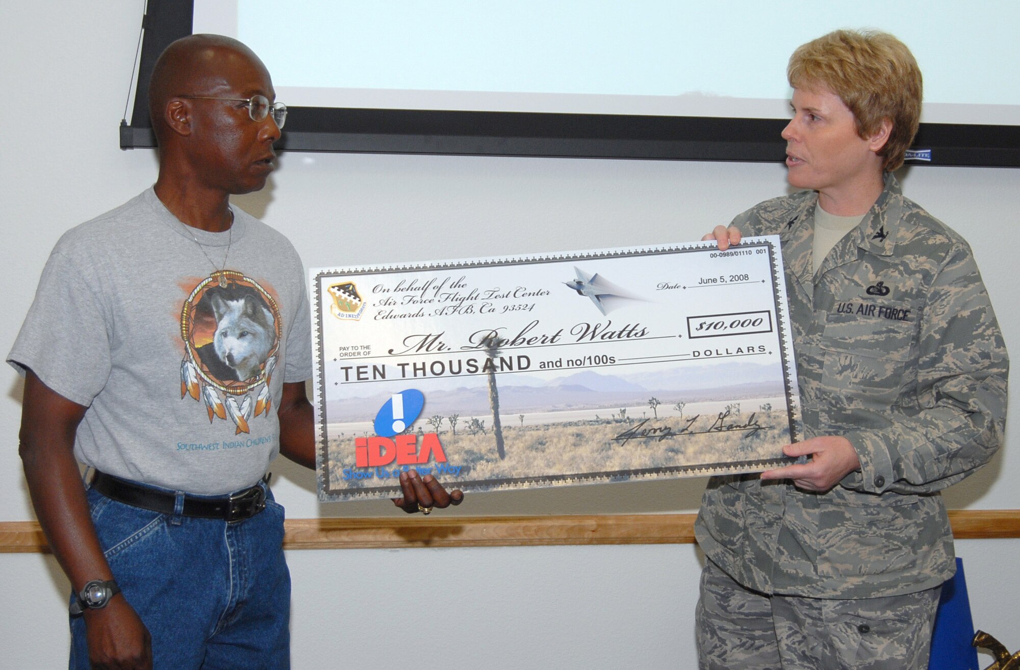 Robert Watts receives a $10,000 check June 11 from Col. Nancy Wharton for an idea he submitted to the Innovative Development through Employee Awareness program. Mr. Watts is a 412th Maintenance Squadron ordnance inspector and Colonel Wharton is the 95th Air Base Wing vice commander. (U.S. Air Force photo/Senior Airman Stacy Sanchez) 