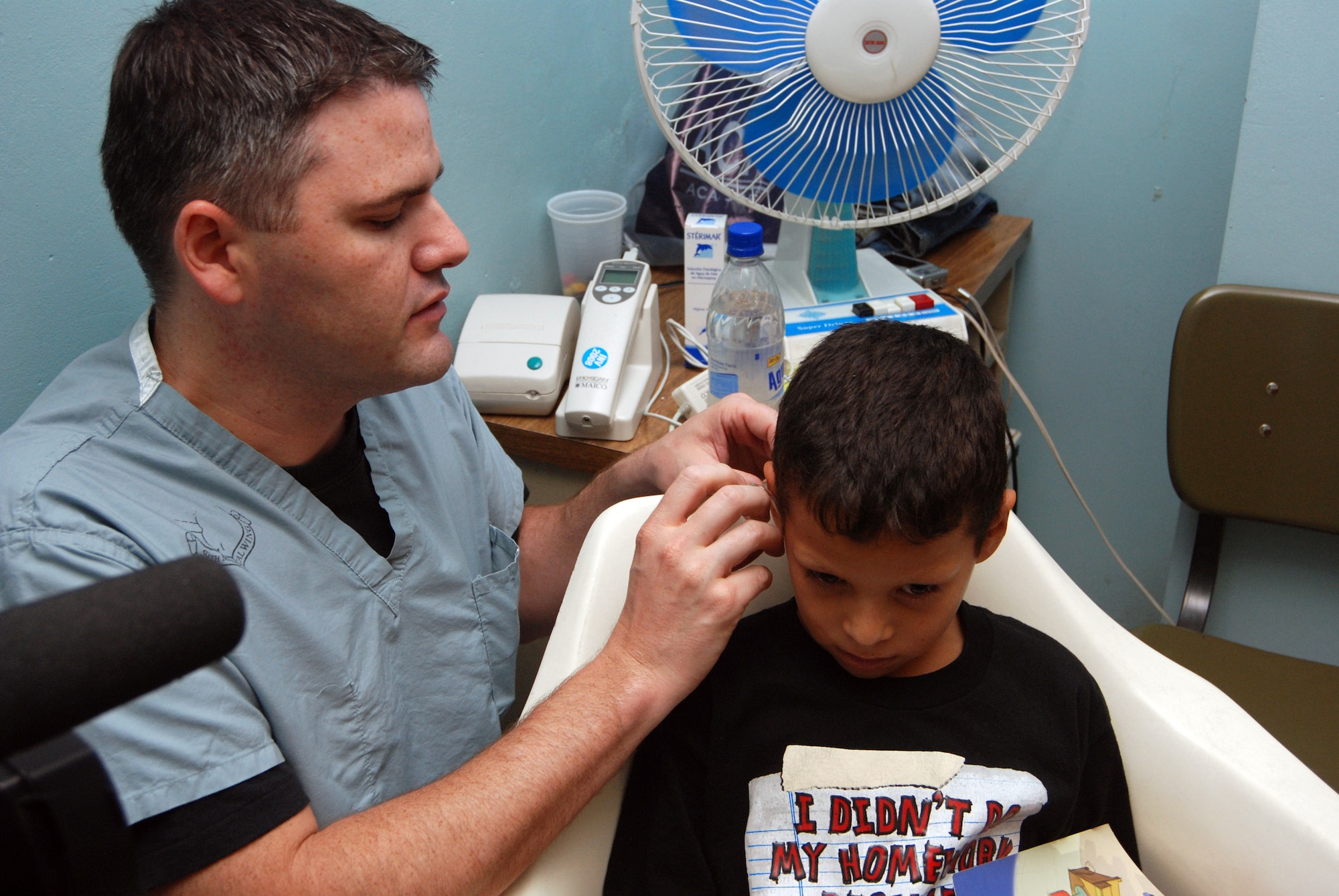 Capt. Matt Williams treats a young patient June 17at Hospital Escuela in Tegucigalpa, Honduras. The audiology team performed more than 160 hearing tests and fitted more than 50 hearing aids during their a two-week readiness training mission to the hospital. Captain Williams an audiologist from Wilford Hall Medical Center in San Antonio, Texas. (U.S. Air Force photo/Tech. Sgt. John Asselin) 