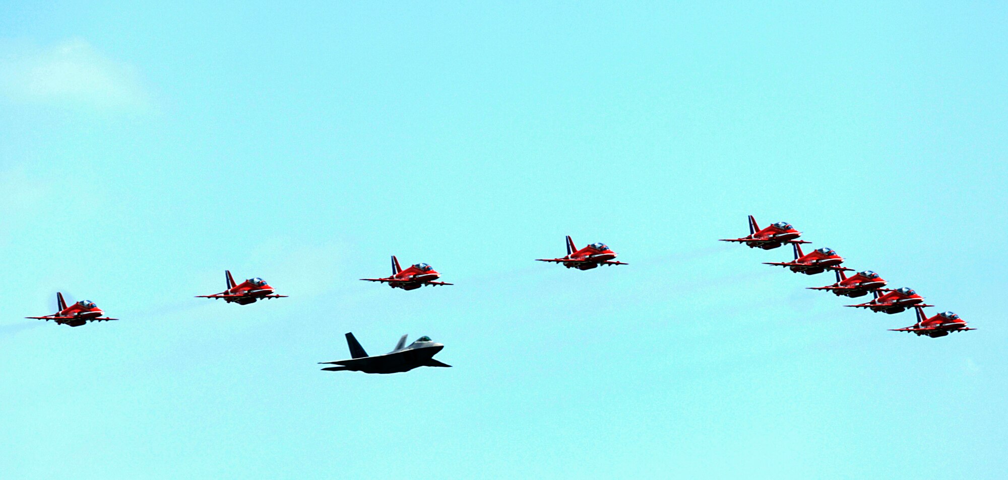 Maj. Paul Moga flies in formation in an F-22 Raptor with the Royal Air Force Aerobatic Team, The Red Arrows, during an afternoon practice flight June 18 at Langley Air Force Base, Va. The aircraft will perform at AirPower over Hampton Roads, the Langley AFB airshow, which is scheduled for June 20 to 22. Major Moga is an F-22 Demonstration Team pilot. (U.S. Air Force photo/Staff Sgt. Samuel Rogers) 
