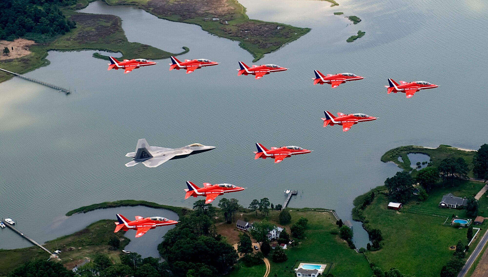 Maj. Paul Moga flies in formation in an F-22 Raptor with the Royal Air Force Aerobatic Team, The Red Arrows, during an afternoon practice flight June 18 at Langley Air Force Base, Va. The aircraft will perform at AirPower over Hampton Roads, the Langley AFB airshow, which is scheduled for June 20 to 22. Major Moga is an F-22 Demonstration Team pilot. (U.S. Air Force photo/Staff Sgt. Samuel Rogers) 
