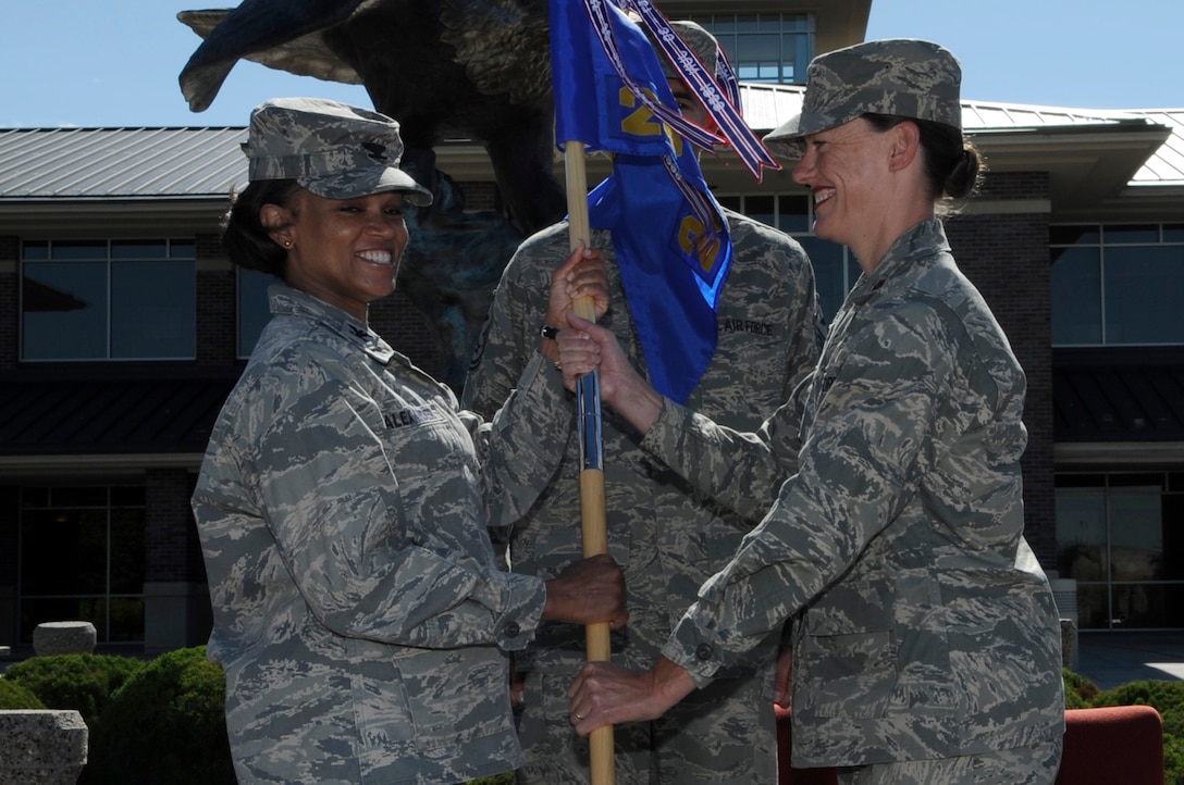 Maj. Launa Bellucci (right) assumes command of the 28th Force Support Squadron by accepting the guidon from Col. Renita Alexander (left), 28th Mission Support Group commander, during a change of command ceremony here, June 19. Major Bellucci is taking command of the 28 FSS a recent merger of the 28th Services Squadron and 28th Mission Support Squadron here, April 11. (U.S. Air Force photo/Airman 1st Class Kasey Zickmund)