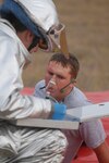 Senior Airman Benjamin Taylor, 12th Medical Group contract management specialist and a base exercise role player, gets treated by a Randolph first responder as he simulates a burn victim in Wednesday's off-base exercise, which took place north of the base in Universal City. (U.S. Air Force photo by Steve White)