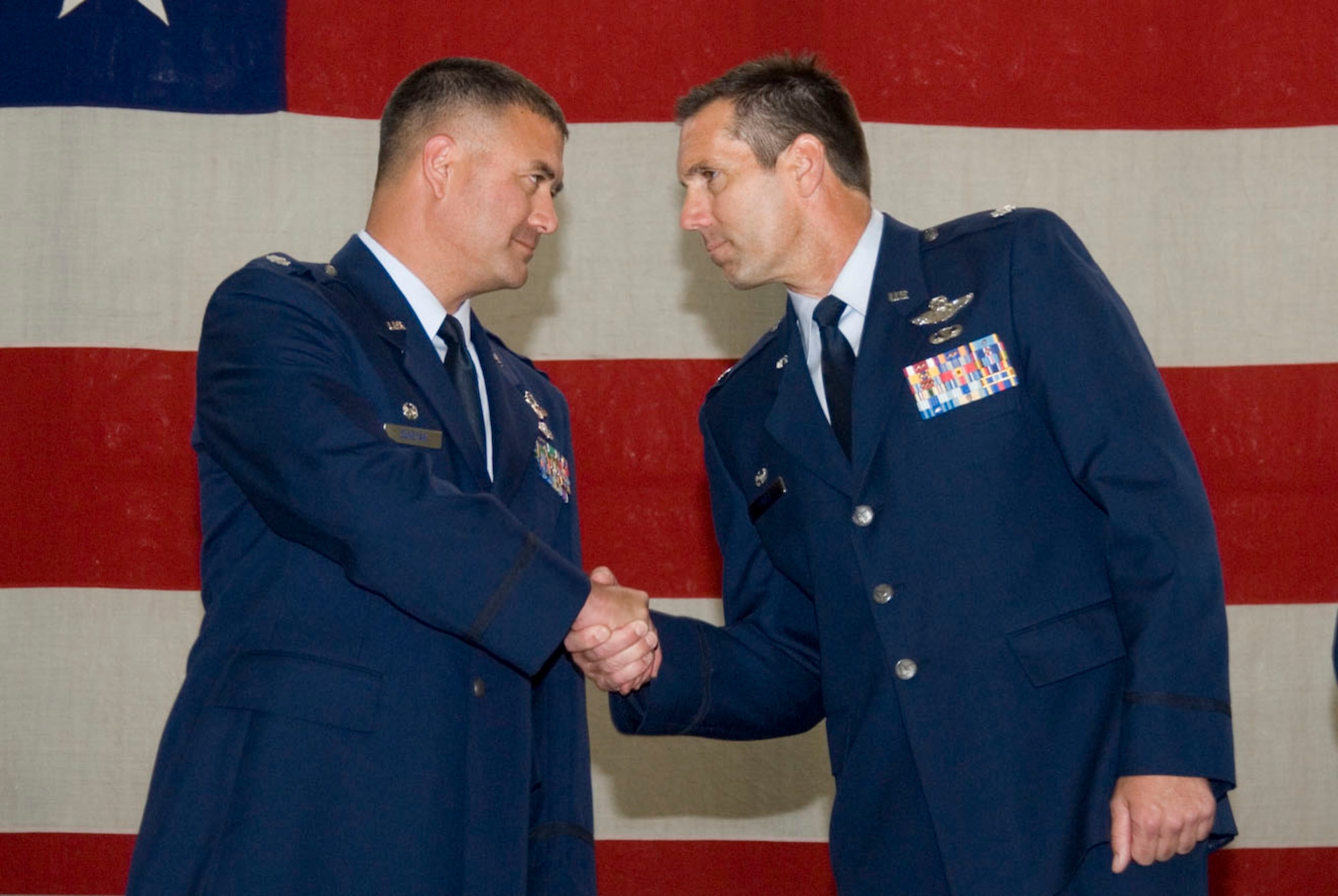 Lt. Col. James "Homey" Fogle, 140th Wing Chief of Plans and former 120th Fighter Squadron Commander congratulates Lt. Col Floyd "Sumo" Dunstan upon assumption of his new command following the formal 120th Fighter Squadron Change of Command ceremony.