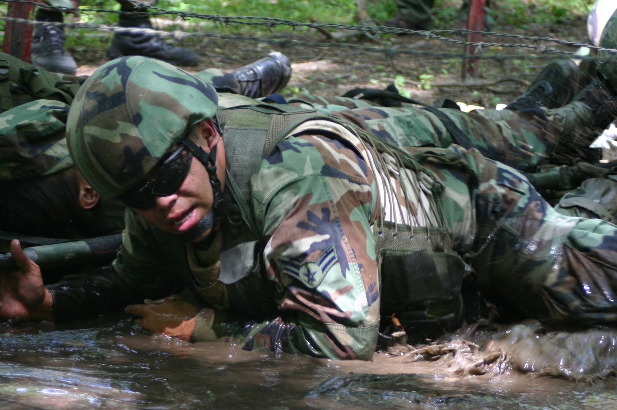 Airman 1st Class Kevin Moreno, 30th Security Forces Squadron, Vandenberg AFB, Calif., low crawls through the mud as he helps transport a victim during Combat First Aid Training June 19 at Fort Dix, N.J. The 10-day course, Phoenix Warrior Training 08-5, is used as pre-deployment training for security forces members. (U.S. Air Force photo/Airman 1st Class Rebekah Phy)