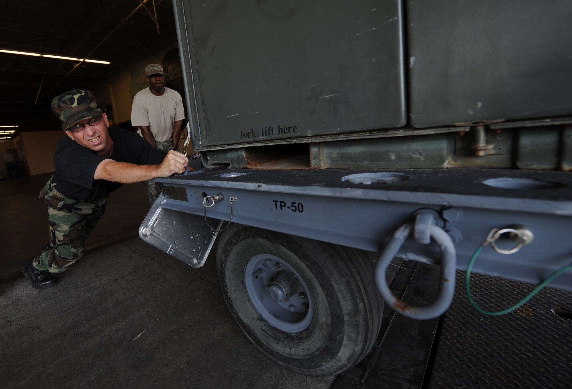 MOODY AIR FORCE BASE, Ga. -- Master Sgt. Ilan Cribb, 23rd Logistics Readiness Squadron NCO-in-charge of cargo movement, pushes a munitions trailer on to a semi-truck here June 12. The munitions are being transported to MacDill Air Force Base, Fla., for exercise Atlantic Strike. (U.S. Air Force photo by Senior Airman Gina Chiaverotti)