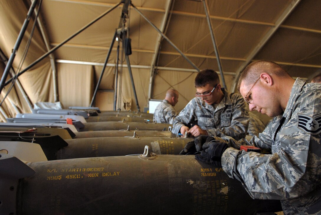 Airmen from the 332nd Expeditionary Maintenance Squadron connect arming lanyards for guided bomb units at Joint Base Balad, Iraq. The lanyard is connected directly to the aircraft, and will initiate internal components and detonation timing. (U.S. Air Force photo/Senior Airman Julianne Showalter)