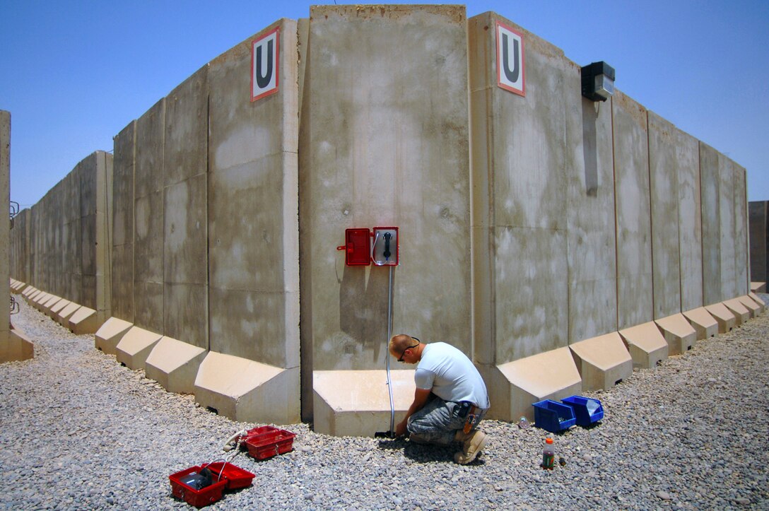 Providing an improved system for accountability checks, Airman 1st Class Marc Spehalski installs an emergency phone June 13 in the Air Force housing area at Joint Base Balad, Iraq. He is deployed from F.E. Warren Air Force Base, Wyo. (U.S. Air Force photo/Senior Airman Julianne Showalter)
