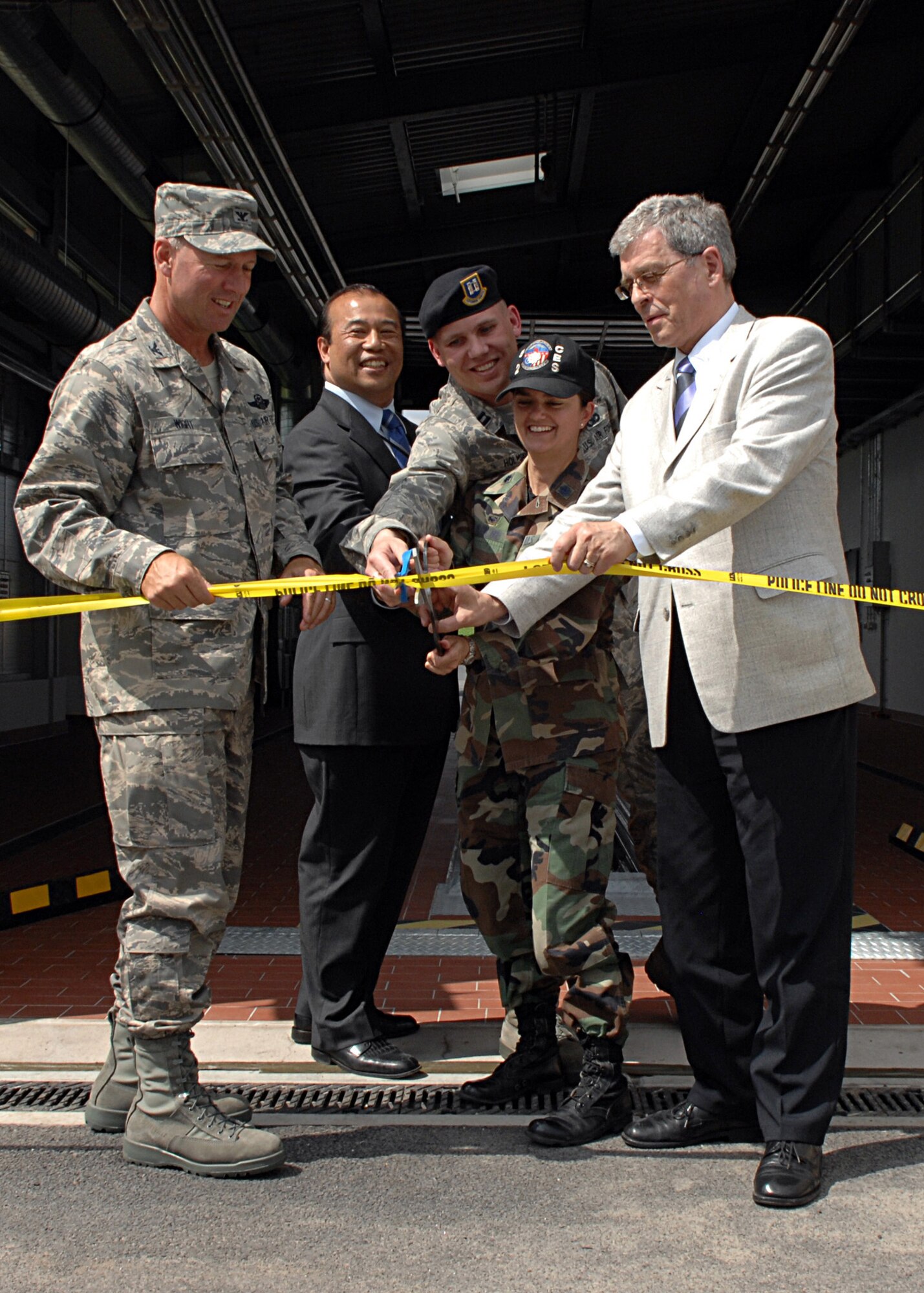 SPANGDAHLEM AIR BASE, Germany -- (from left to right) Col. Lee Wight, 52nd Fighter Wing commander, Mr. Terry Bautista, Army Corps of Engineers chief of engineering and construction, Capt. Gregory Holmgren, 52nd Security Forces Squadron commander, Lt. Col. Kathryn Kolbe, 52nd Civil Engineer Squadron commander, and Mr. Roger Graef, Country Commissioner of Bitburg, cut the ribbon June 17, 2008. The ribbon cutting ceremony was done for the grand opening of the privately owned vehicle and large vehicle inspection station gates.  (U.S. Air Force photo by Airman Staci Miller)