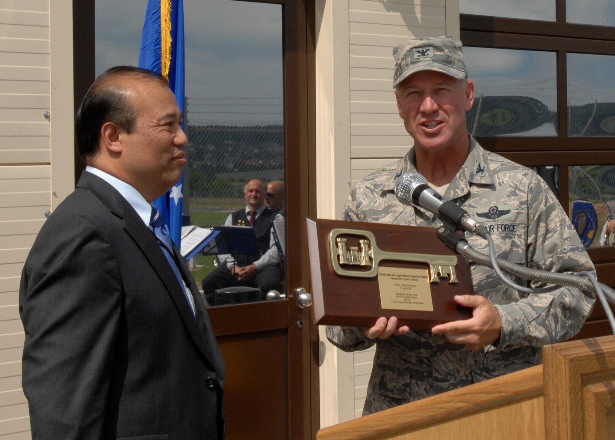 SPANGDAHLEM AIR BASE, Germany -- Col. Lee Wight, 52nd Fighter Wing commander, accepts a key plaque from Mr. Terry Bautista, Army Corps of Engineers chief of engineering and construction June 17, 2008. The plaque was awarded to celebrate the successful completion and opening of the privately owned vehicle and large vehicle inspection station gates. (U.S. Air Force photo by Airman Staci Miller)