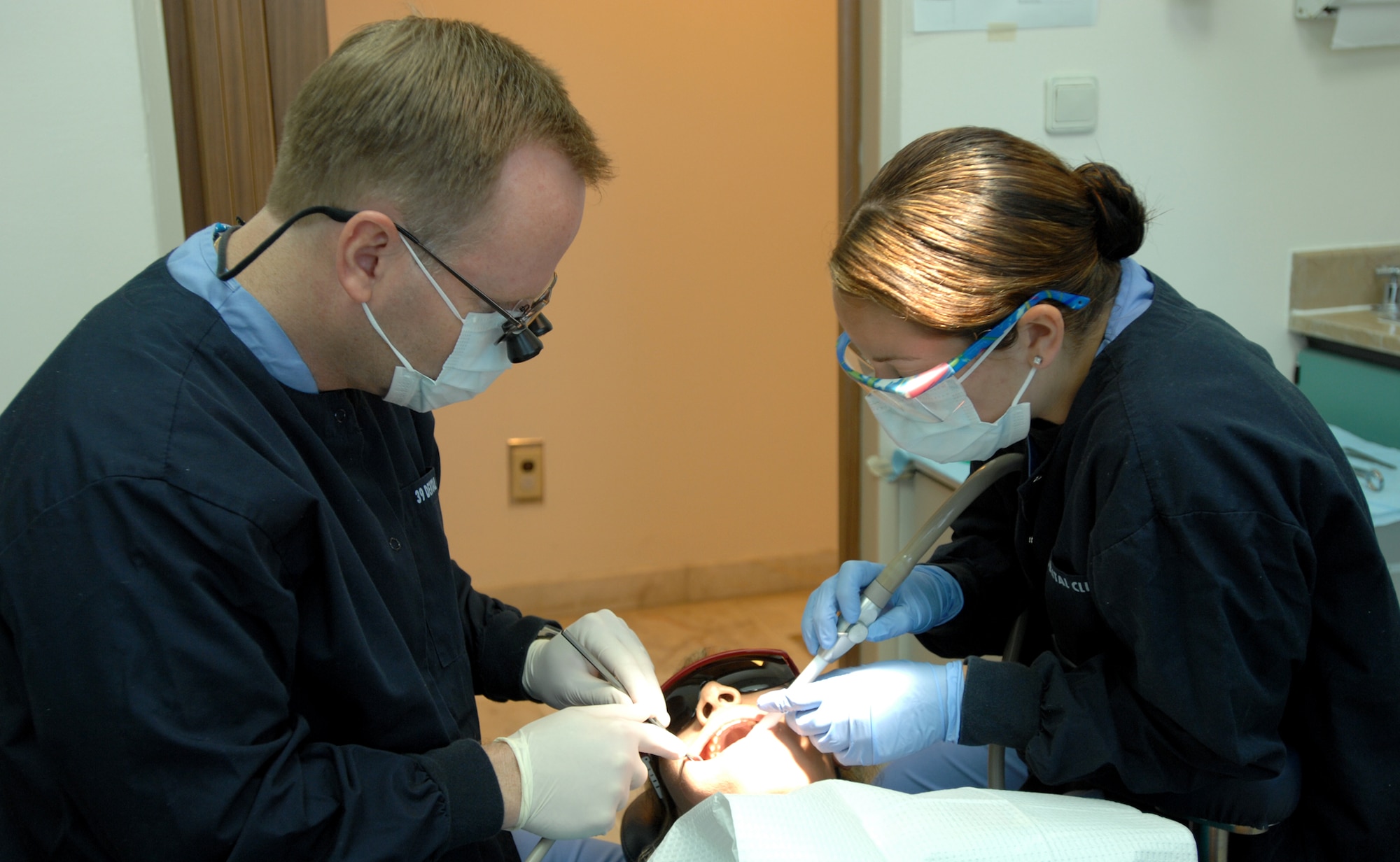 Maj. Kyle Pelkey and Airman 1st Class Crystal Senna, 39th Medical Operations Squadron dental clinic, examine a patient before extracting a tooth. The dental clinic provides between 500 and 800 procedures including exams and teeth cleaning. (U.S. Air Force photo by Senior Airman Lauren Padden)