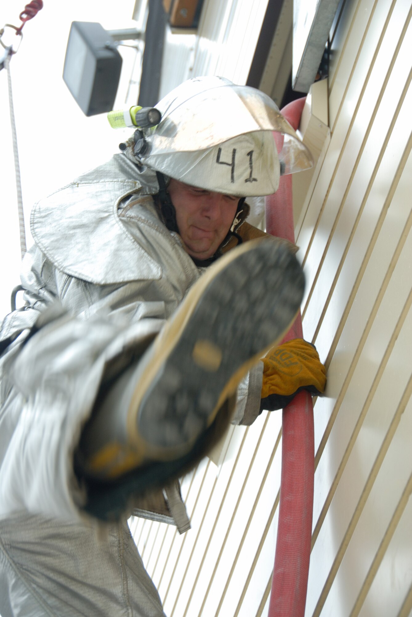 MISAWA AIR BASE, Japan -- Airman 1st Class Timothy McCutcheon, 35th Civil Engineer Squadron, swings out of a second floor window onto a water hose during firefighter training on June 13, 2008.  Firefighters were taught how to maneuver through debris and climb out windows as part of the training.  (U.S. Air Force photo by Senior Airman Laura R. McFarlane)