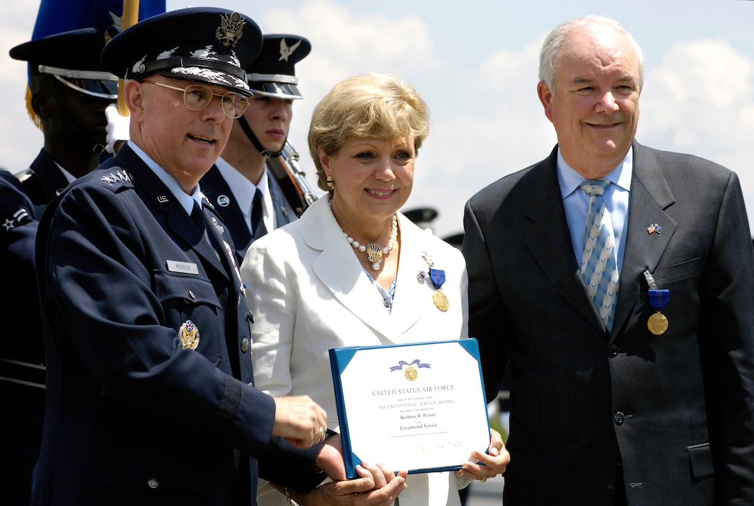 Air Force Chief of Staff Gen. T. Michael Moseley, left, presents Barbara Wynne, wife of Air Force Secretary Michael W. Wynne, right, with an award during a farewell ceremony for Wynne at the U.S. Air Force Memorial in Arlington, Va., June 20, 2008.  