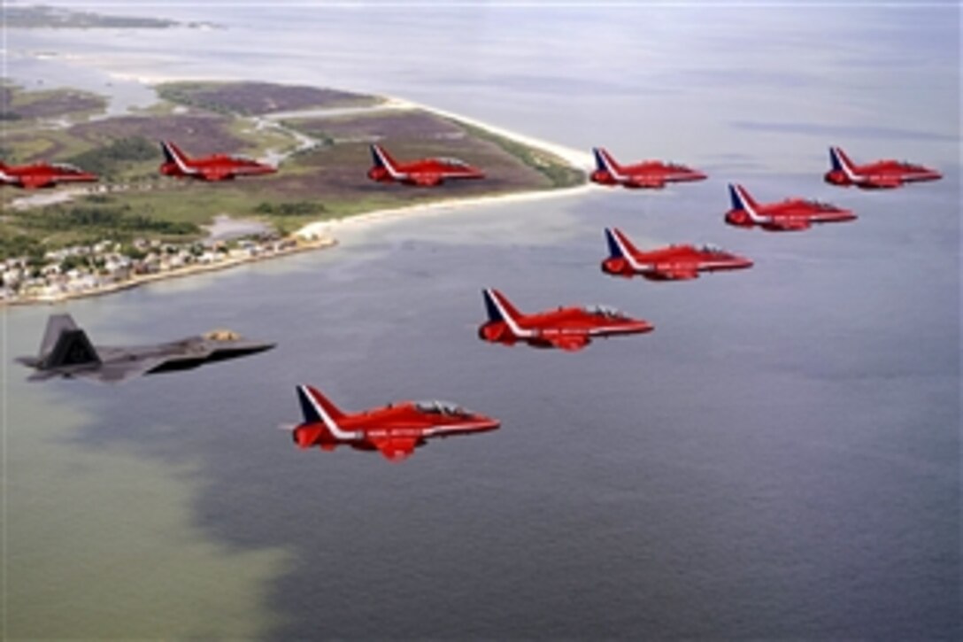 A U.S. F-22 Raptor flies with the British Royal Air Force aerobatic team, The Red Arrows, during a practice flight June 18, 2008, over Langley Air Force Base, Va., for an air show June 20, 2008.