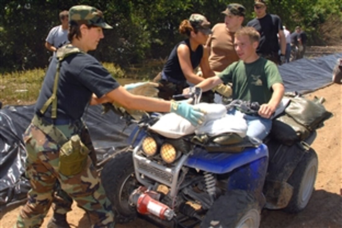 Members of the Iowa Air National Guard's 185th Air Refueling Wing pull sandbags from a resident's all-terrain vehicle on a levee north of Burlington, Iowa, June 17, 2008. The 185th ARW mobilized 400 Airmen to fight flooding in eastern Iowa. 