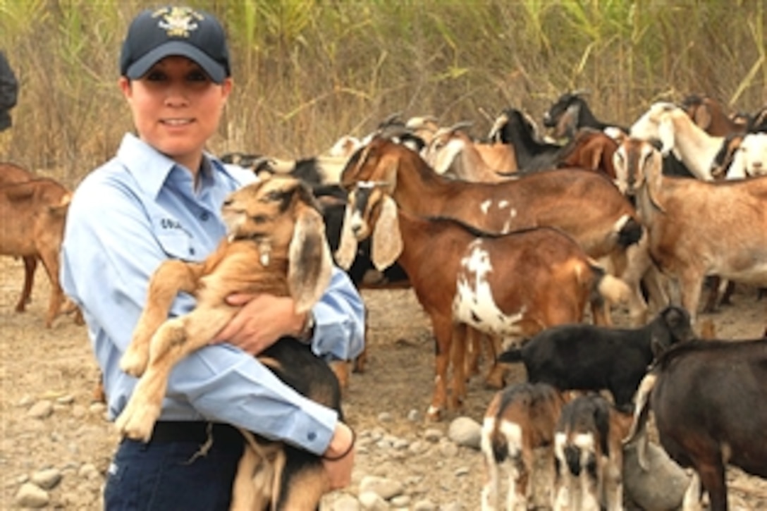 U.S. Navy Petty Officer 2nd Class Melody Colangeli, assigned to the USS Boxer, holds a baby goat while visiting a family goat ranch with a team of Army veterinarians in the Huacho region of Peru during an Operation Continuing Promise 2008 veterinary civil affairs project, Huacho, Peru, June 13, 2008. Colangeli is an aviation maintenance administrationman.
