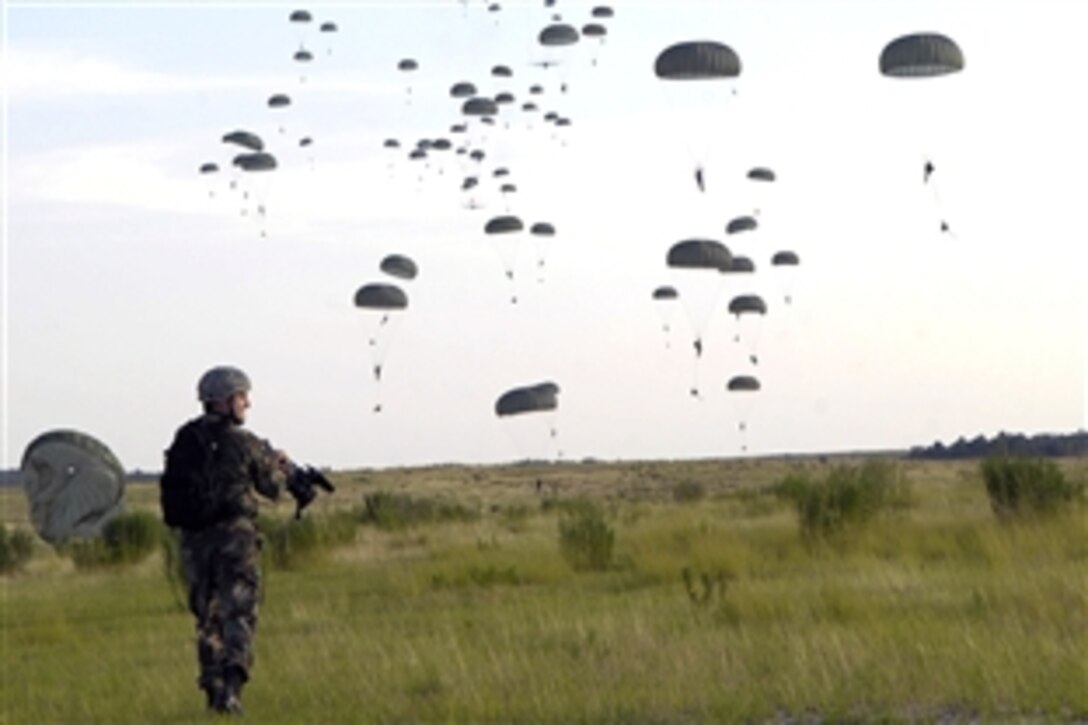 U.S. Air Force Senior Airman Cory Boatwright videotapes U.S. Army soldiers assigned to 82nd Airborne Division as they parachute from a C-17 Golbemaster III aircraft during a joint forcible entry exercise on Fort Bragg, N.C., June 17, 2008.  Boatwright is assigned to the 1st Combat Camera Squadron. 