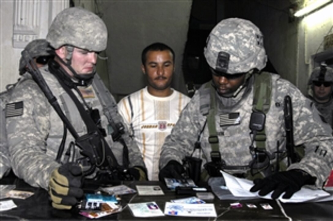 U.S. Army soldiers examine documents and other items taken from detainees captured during a cordon and search operation in Jazzair, Iraq, June 16, 2008. The soldiers are assigned to the 4th Infantry Division's 1st Battalion, 8th Infantry Regiment.