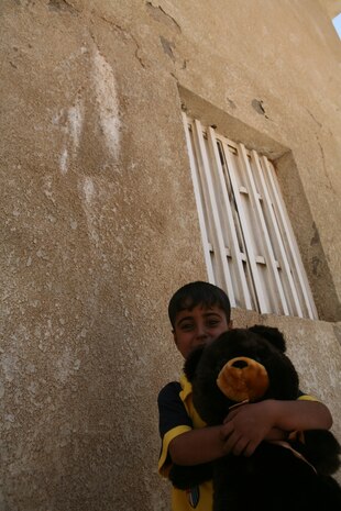 Five-year-old Ahmed clenches a teddy bear given to him by Marines from Company B, Police Transition Team 8, Regimental Combat Team 1, June 21. Ahmed has a serious medical condition that affects his heart, and if left untreated will kill him at an early age. (Official Marine Corps photo by Cpl. Chris T. Mann)