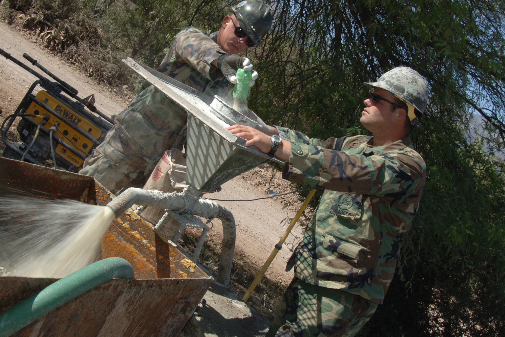U.S. Navy Petty Officer 2nd Class Brad Tom and U.S. Navy Petty Officer 3rd Class Chad Riechmann, mechanics assigned to Task Force New Horizons, mix material that adds viscosity to a water well drill, June 19, in Huanta, Peru  where U.S. Seabeas are constructing a water well in support of New Horizons Peru-2008, a U.S. and Peruvian humanitarian mission set on providing relief to underprivileged Peruvians. (U.S. Air Force photo/Tech. Sgt. Kerry Jackson)