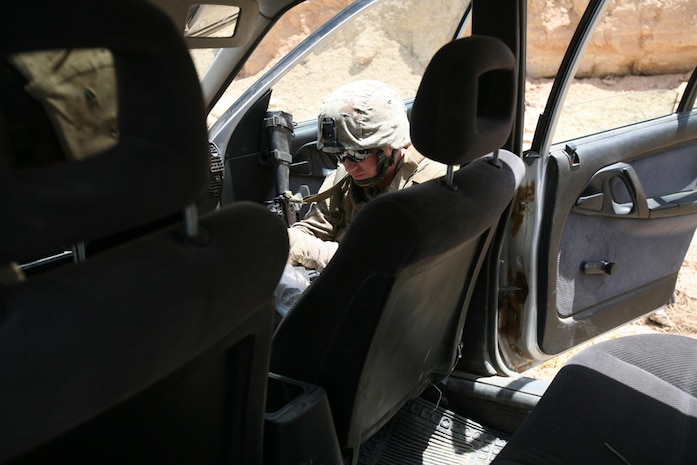 Cpl. Isaac M. Hanson, 30, an assaultman with Company I, 3rd Battalion, 4th Marine Regiment, Regimental Combat Team 5, searches the passenger area of a vehicle in Hit, Iraq, June 21. Marines detained the driver of the vehicle after they confirmed he was a known insurgent. Marines were able to detain three additional insurgents by the end of the day that will help make Hit safer for everyone.::r::::n::
