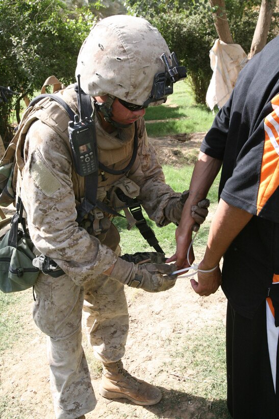 Lance Cpl. Edwin S. Contreras, 19, an assaultman with Company I, 3rd Battalion, 4th Marine Regiment, Regimental Combat Team 5, flexi-cuffs a known insurgent in Hit, Iraq, June 21. Marines with Company I detained four known insurgents during an intelligence raid in the Hit area. The detainment of the four insurgents helped make the area of Hit safer for Coalition forces and the local Iraqi population. ::r::::n::