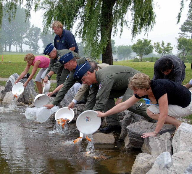 OSAN AIR BASE, Republic of Korea -- Team Osan leadership release 480 fish into Lakes at Osan Golf Course pond June 20. The fish, donated by Mr. K. D. Lee, an honorary commander, will help control the algae population in the pond. (U.S. Air Force photo/Master Sgt. Marlin Zimmerman)