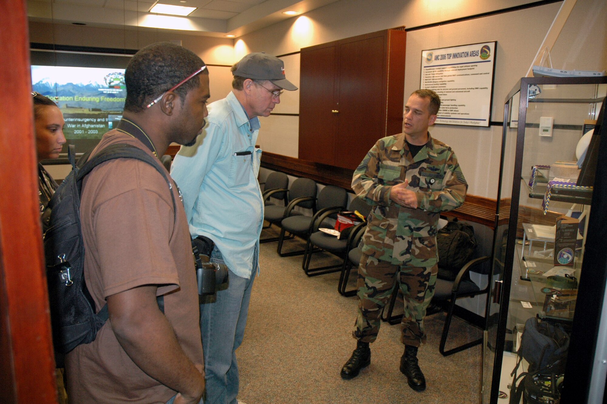 Master Sgt. Michael Harris, U.S. Air Force Expeditionary Center's Air Mobility Battlelab, describes some battlelab initiatives to Tatiana El-Khouri, Steven Wright and John Finger -- all artists participating in an official visit to the USAF EC as part of the Air Force Art Program.  Over a three-day visit, the artists saw the armory, the Center campus and in-the-field training for Phoenix Warrior and Eagle Flag courses.  (U.S. Air Force Photo/Tech. Sgt. Scott T. Sturkol)