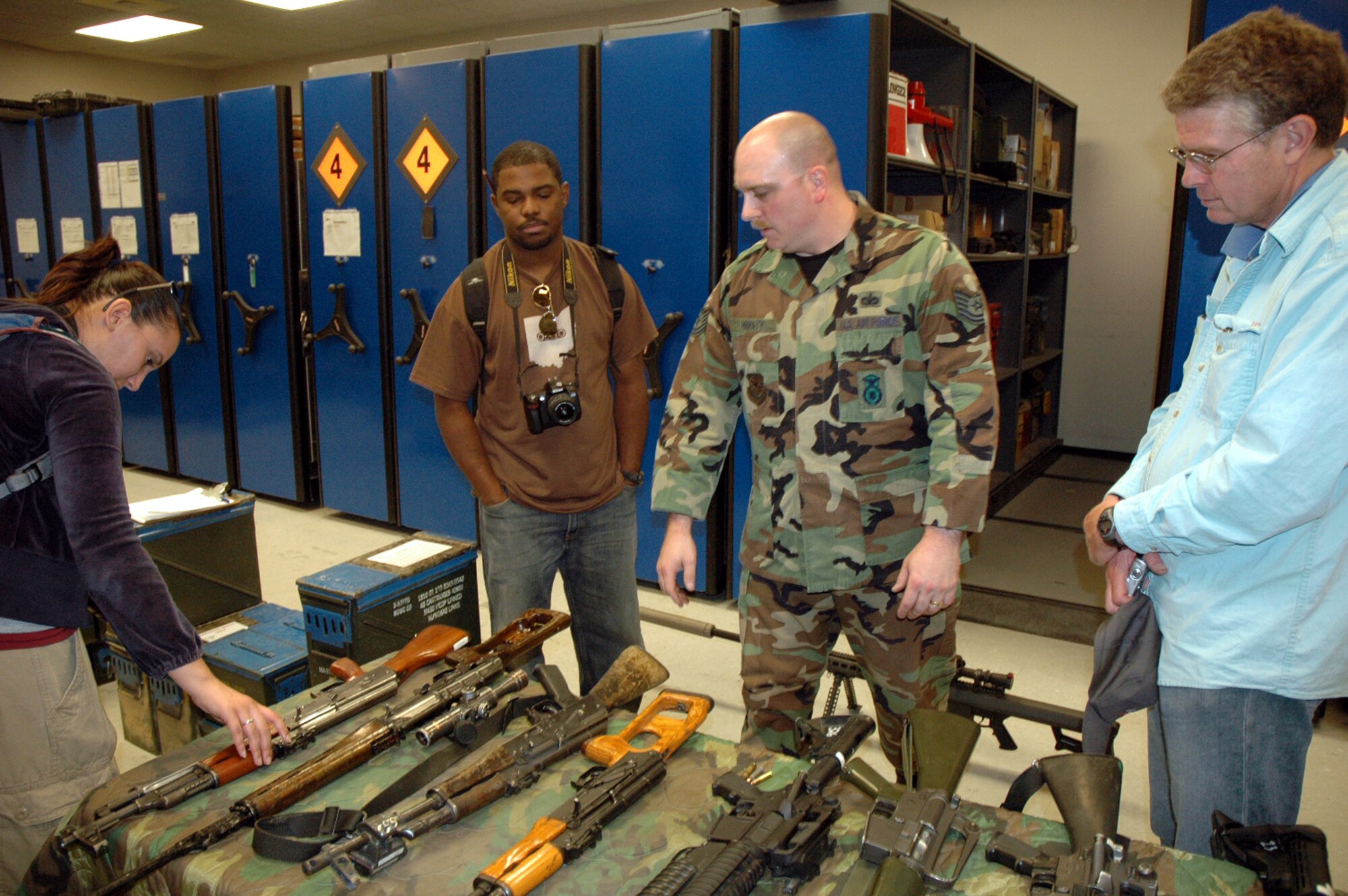 Tech. Sgt. Sean Heraty, U.S. Air Force Expeditionary Center armory, describes what's in the armory to Tatiana El-Khouri, Steven Wright and John Finger -- all artists participating in an official visit to the USAF EC as part of the Air Force Art Program.  Over a three-day visit, the artists saw the armory, the Center campus and in-the-field training for Phoenix Warrior and Eagle Flag courses.  (U.S. Air Force Photo/Tech. Sgt. Scott T. Sturkol)