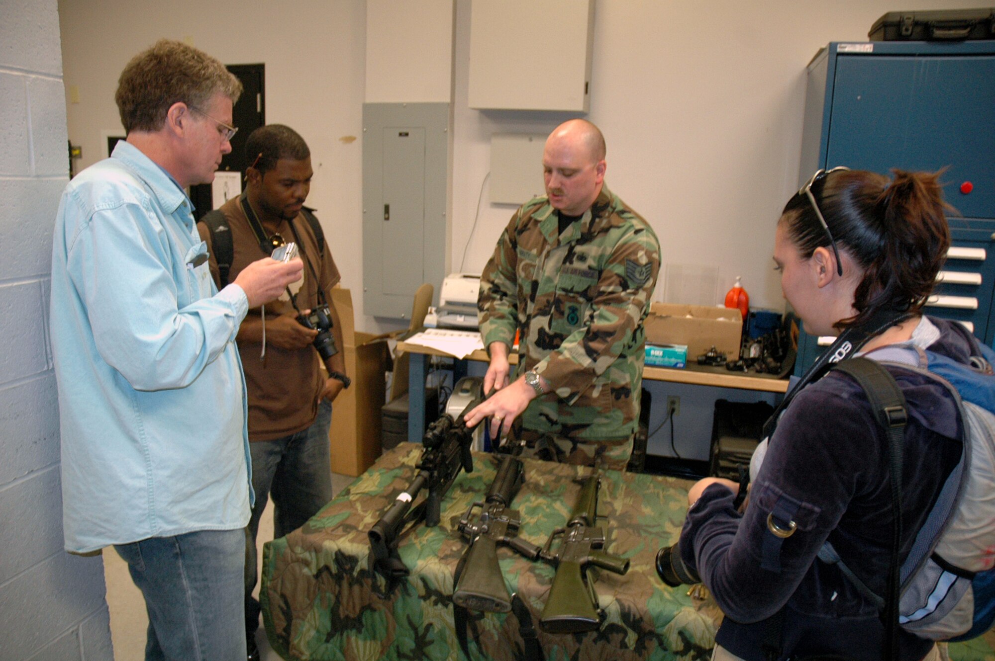 Tech. Sgt. Sean Heraty, U.S. Air Force Expeditionary Center armory, describes what's in the armory to Steven Wright, John Finger and Tatiana El Khouri -- all artists participating in an official visit to the USAF EC as part of the Air Force Art Program.  Over a three-day visit, the artists saw the armory, the Center campus and in-the-field training for Phoenix Warrior and Eagle Flag courses.  (U.S. Air Force Photo/Tech. Sgt. Scott T. Sturkol)