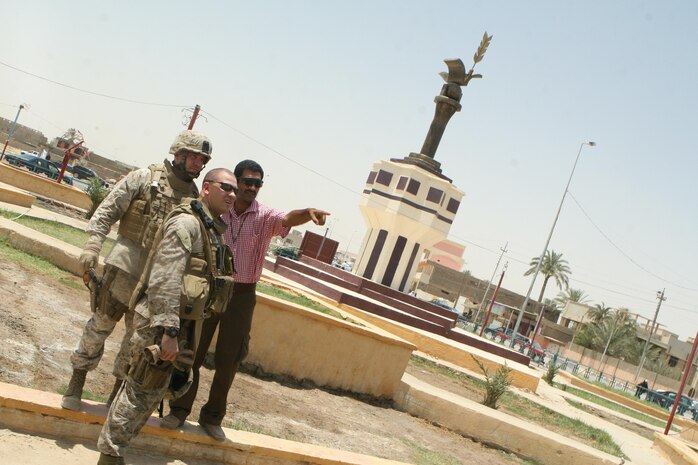 Chief Warrant Officers 2 Eric Jett (left) and (middle) Jason Morris, team leaders with Civil Affairs Detachment 2, attached to Regimental Combat Team 1, stand alongside Mahmoud Marre, a local Iraqi contractor, in the front of the statue overlooking the newly-renovated 17th Street Municipal Building June 22. The unwavering contractor, with his own money, built the statue to serve as a symbol of peace in Ramadi. "We decided to place a statue with a bird and a globe in front of the building," Marre said. "The new statue is meant to be a symbol of peace in Ramadi; a new chapter for the city. In the past Saddam's face was at that site. It was meant to instill fear in us and remind us that he is an enemy of peace. We removed the old statue as a way out saying this is the new Ramadi, free of Saddam and free of violence."