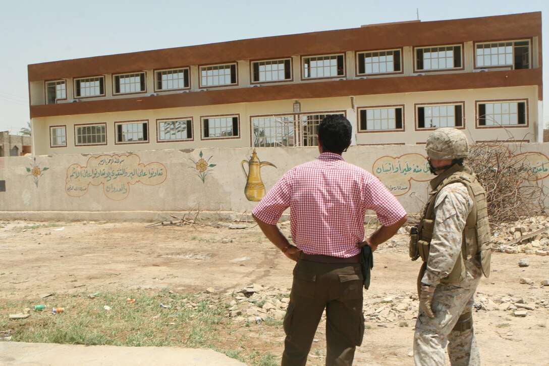Mahmoud Marre, a local Iraqi contractor, and Chief Warrant Officer 2 Eric Jett, a team leader with Civil Affairs Detachment 2, Regimental Combat Team 1, look over the newly-constructed 17th Street Municipal Building. The municipal building will essentially be the local government's city hall.