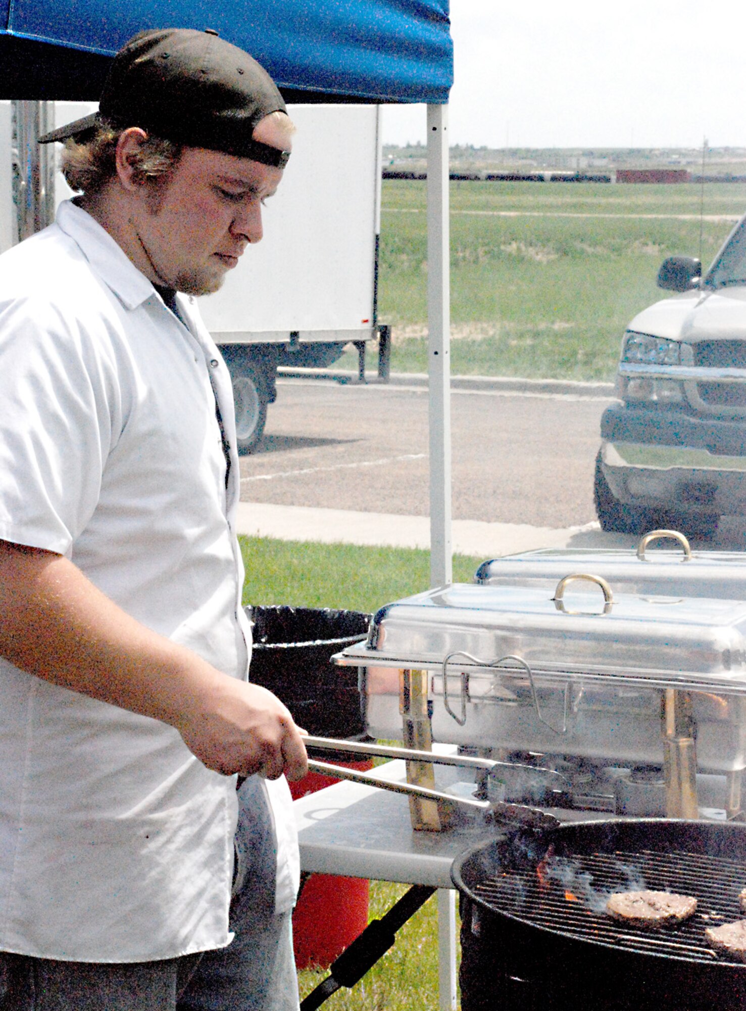 Michael Thrush, cook, grills hamburgers at lunch time during the Father's Day event.