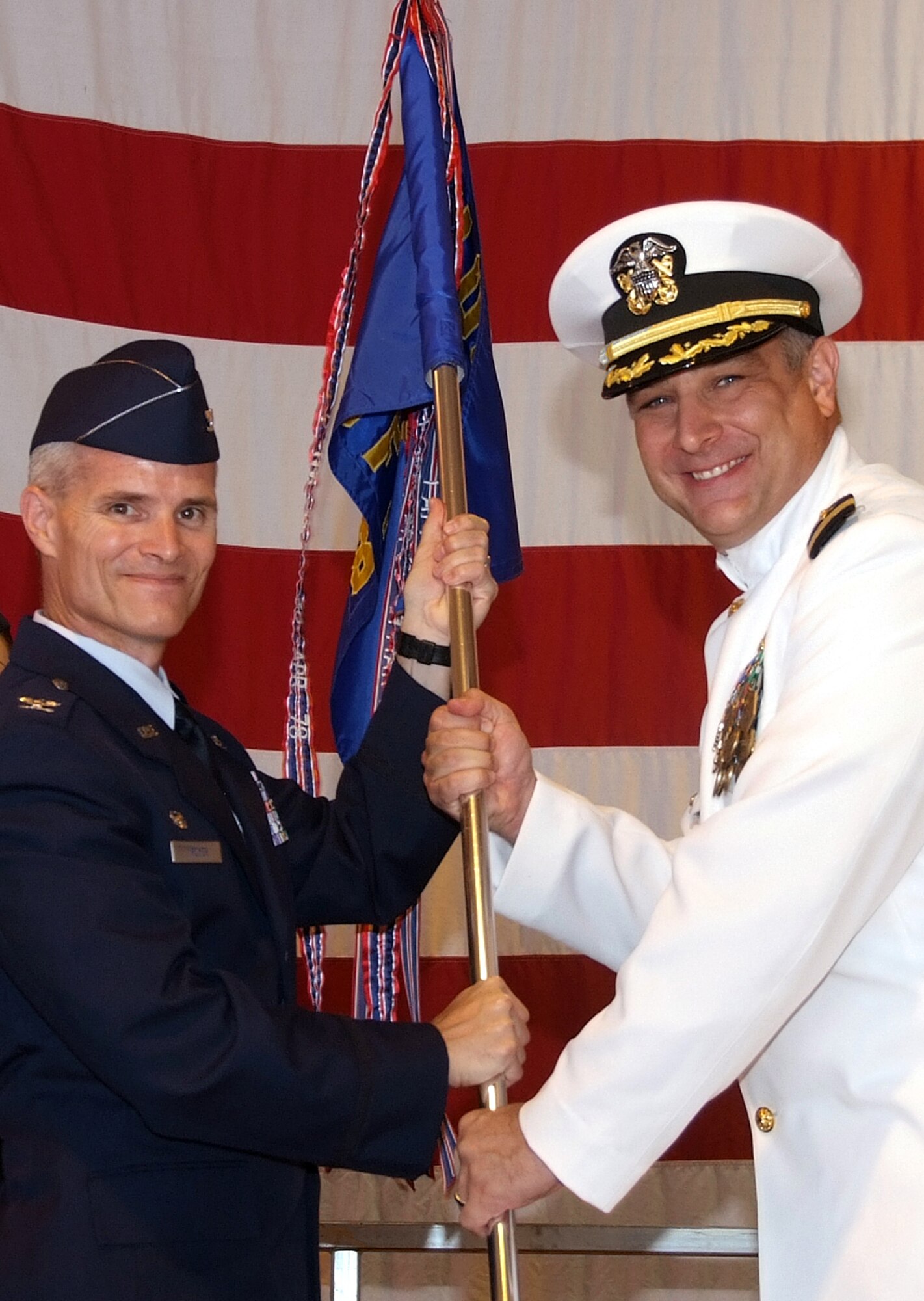 Air Force Col. Douglas E. Troyer, left, 71st Operations Group commander, gives the 8th Flying Training Squadron guidon to the squadron’s new commander, Navy Cmdr. Roger L. Curry, during a change of command ceremony, June 20, at Vance AFB, Okla. (U.S. Air Force photo by Terry Wasson)