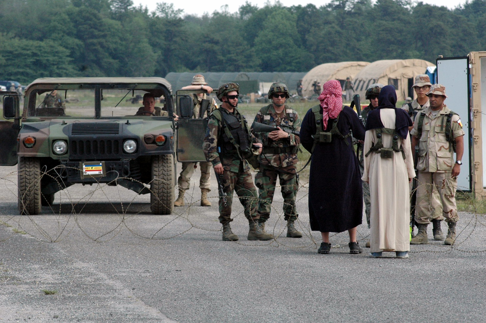 Students and role plays play out a scenario at the entry control point to the main camp area for Air Force Exercise Eagle Flag 08-5 June 21, 2008, at Naval Air Engineering Station Lakehurst, N.J.  Eagle Flag is operated by the U.S. Air Force Expeditionary Center's Expeditionary Operations School and 421st Combat Training Squadron at Fort Dix, N.J.  The exercise tests and trains Airmen in expeditionary combat support skills.  (U.S. Air Force Photo/Tech. Sgt. Scott T. Sturkol)