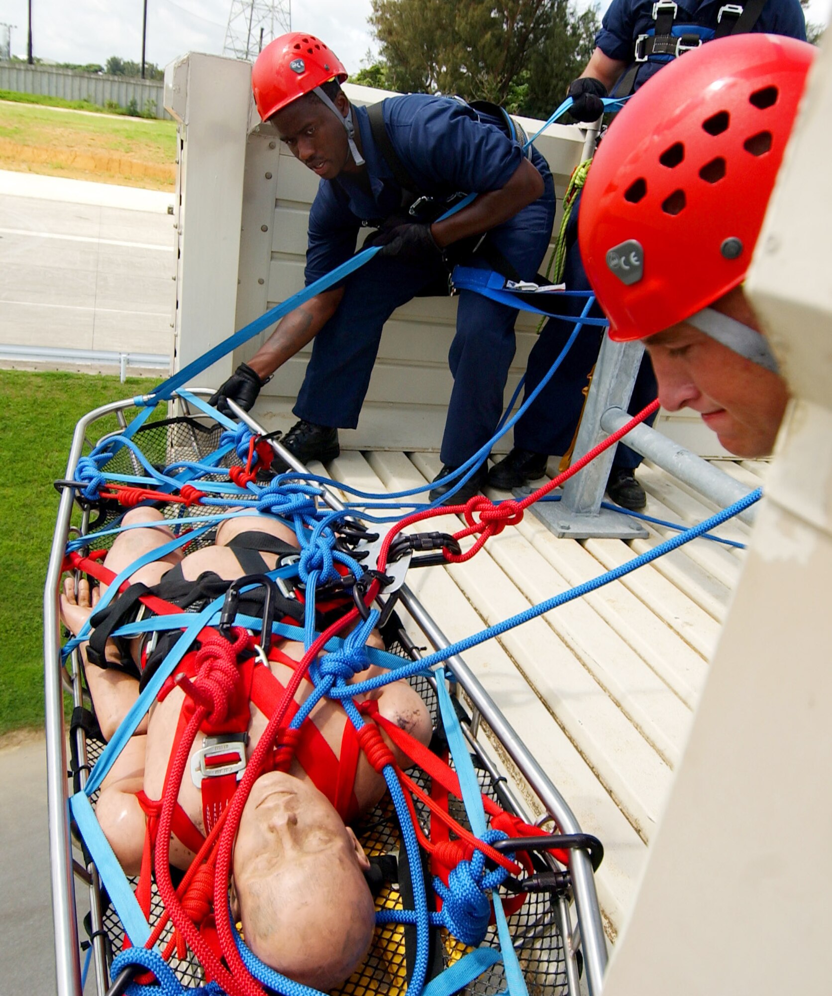 Senior Airman Brett Williams and Senior Airman Derek White lower a simulated injured victim during the Rescue I course provided by Detachment 1, 554th Rescue Squadron here June 17. Airman Williams is assigned to the 3rd Civil Engineer Squadron at Elmendorf Air Force Base, Alaska. Airman White is assigned to the 18th Civil Engineer Squadron at Kadena Air Base, Japan. (U.S. Air Force photo/Tech. Sgt. Rey Ramon)