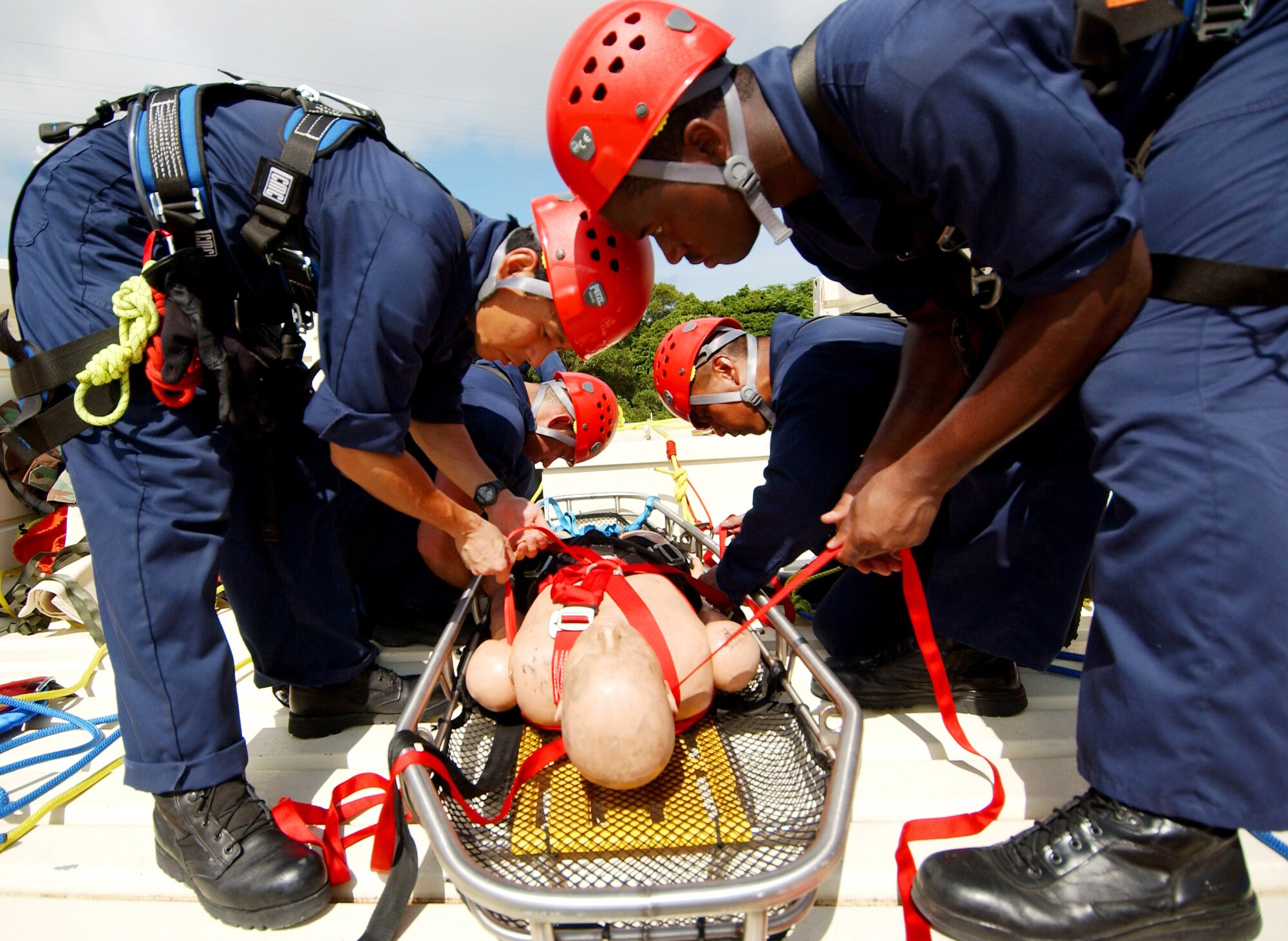 Staff Sgt. Roderick Marquez and Senior Airman Derek White along with other team members secure an unconscious victim in a stokes basket before lowering off the tower June 17. Sergeant Marquez is assigned to 36th Civil Engineer Squadron at Andersen Air Force Base, Guam. Airman White is assigned to the 18th Civil Engineer Squadron at Kadena Air Base, Japan. (U.S. Air Force photo/Tech. Sgt. Rey Ramon)